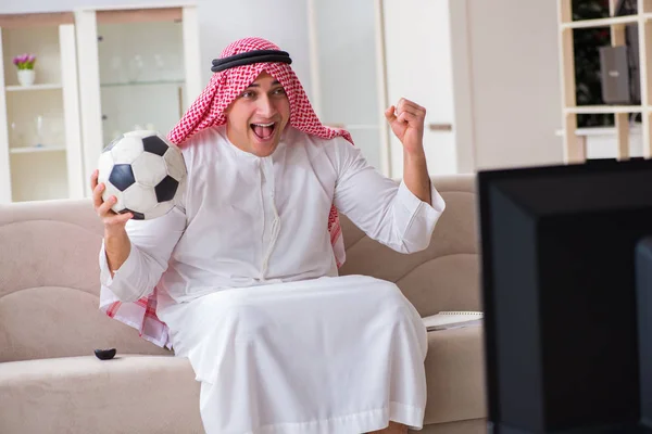 Arab businessman watching tv at home