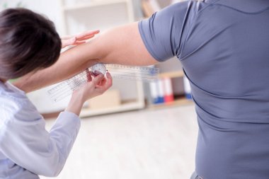 Doktor hastaların eklem esnekliğini gonimetreyle kontrol ediyor.