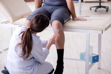 Doktor hastaların eklem esnekliğini gonimetreyle kontrol ediyor.