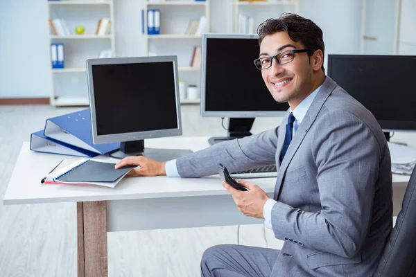 Geschäftsmann sitzt vor vielen Bildschirmen — Stockfoto