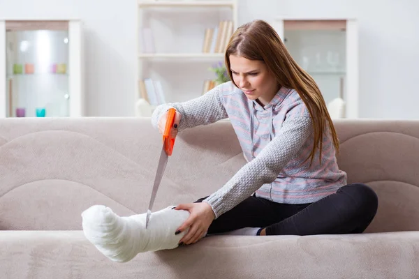 Jeune femme avec jambe cassée à la maison — Photo