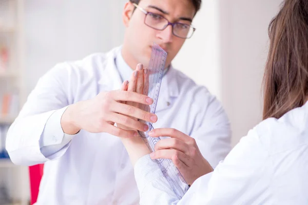Doctor checking patients joint flexibility with gonimeter — Stock Photo, Image