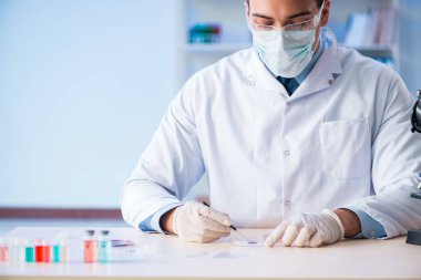 Laboratuvar asistanı hastanede kan örneklerini test ediyor.