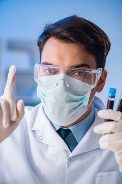 Laboratuvar asistanı hastanede kan örneklerini test ediyor.