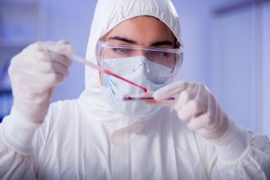 Laboratuvar asistanı hastanede kan örneklerini test ediyor.