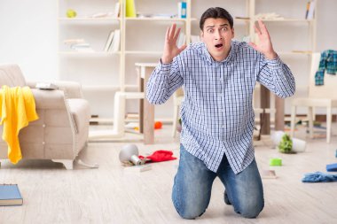 Hırsızlar tarafından soyulduktan sonra evini bulan bir adam.