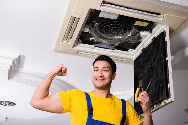 Repairman repairing ceiling air conditioning unit — Stock Photo, Image