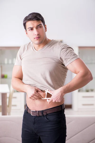 Hombre midiendo grasa corporal con pinzas — Foto de Stock