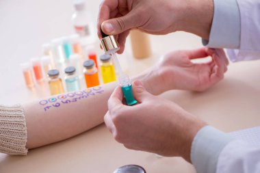 Hastanedeki hastanın alerji reaksiyonunu test eden doktor.