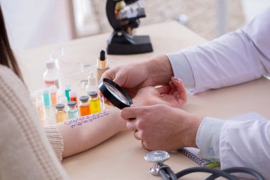 Hastanedeki hastanın alerji reaksiyonunu test eden doktor.