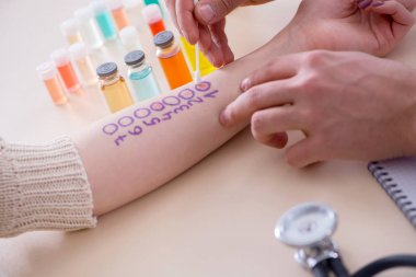 Hastanedeki hastanın alerji reaksiyonunu test eden doktor.