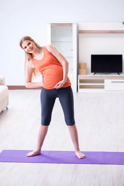 Hamile kadın evde spor yapıyor. — Stok fotoğraf
