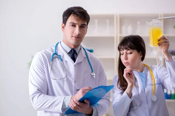 Dos doctores discutiendo plasma y transfusión de sangre — Foto de Stock