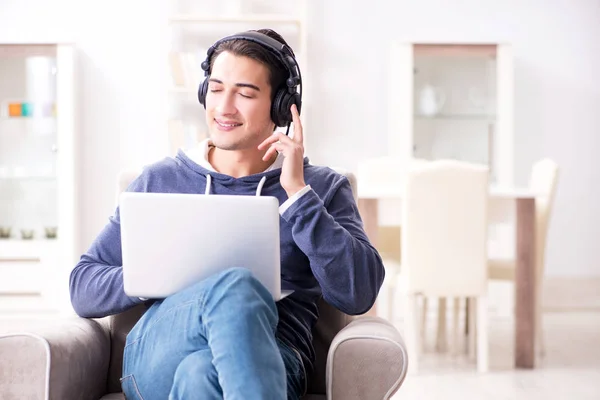 Jonge knappe man die naar muziek luistert met koptelefoon — Stockfoto