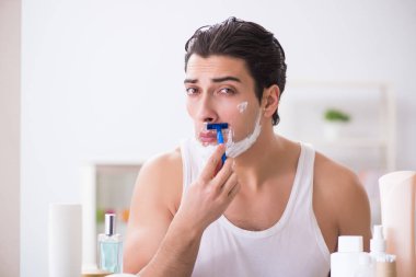 Genç yakışıklı adam sabah erkenden tıraş oluyor.