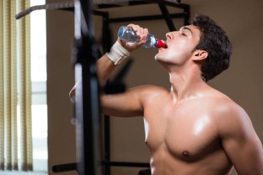 Spor salonunda su içen susamış bir adam.