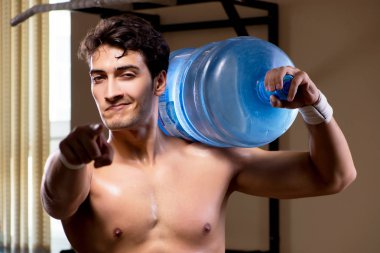 Büyük su şişeli kaslı adam.