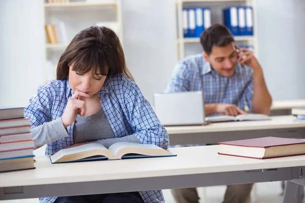 Estudiantes sentados y estudiando en la universidad — Foto de Stock