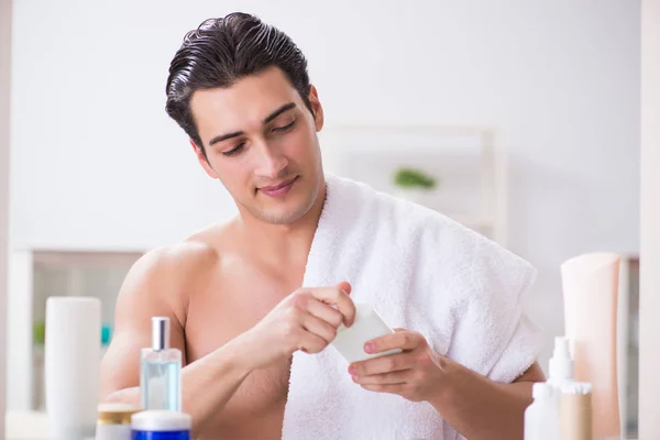 Young man is getting prepared for working day in bathroom — Stock Photo, Image