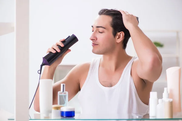 Jeune homme sèche ses cheveux le matin — Photo