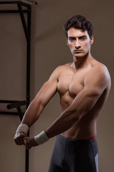 Hombre musculoso rasgado en gimnasio haciendo deportes —  Fotos de Stock