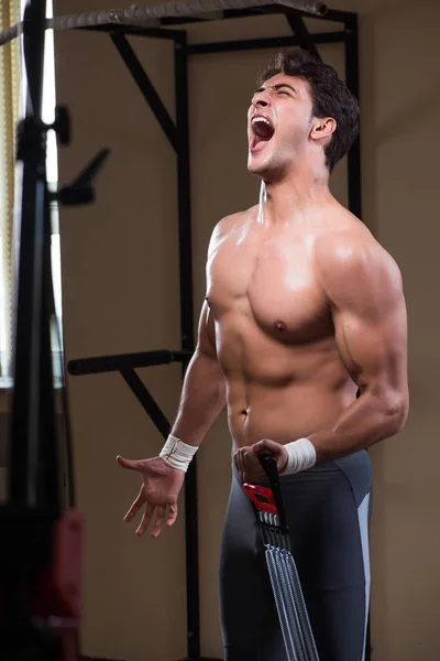 Hombre trabajando en el gimnasio con muelles — Foto de Stock