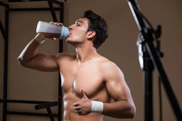 Homme avec des suppléments nutritifs dans la salle de sport — Photo