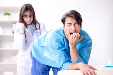 Komik adam şırınga iğnesine hazırlanıyor.