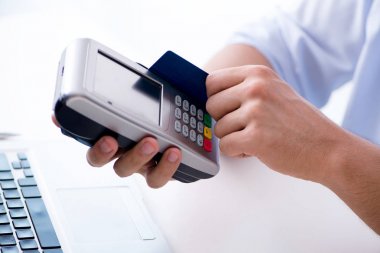 POS terminali ile kredi kartı işlemi yapan adam