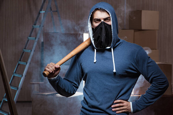 Хулиган с летучей мышью в темной комнате