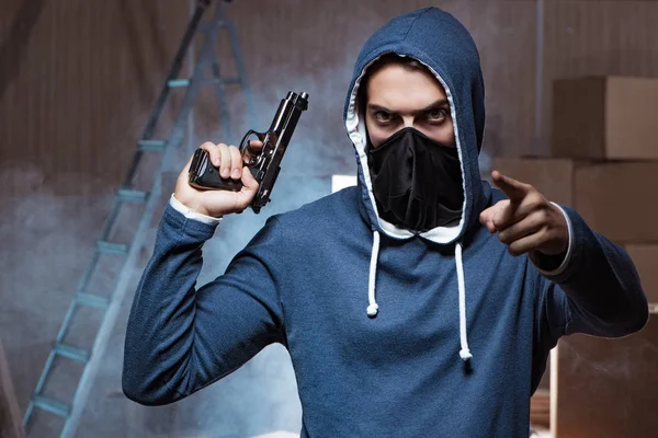 Agresywny mężczyzna z bronią noszący maskę na twarzy — Zdjęcie stockowe