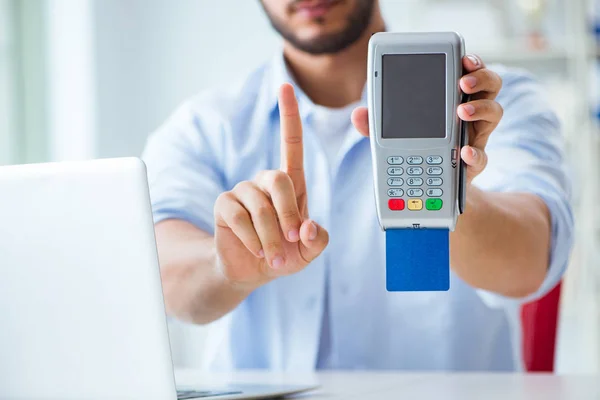 Man processing credit card transaction with POS terminal