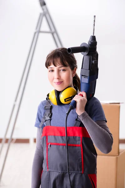 Woman contractor with hand drill at construction site