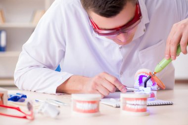 Tıp laboratuarına diş implantı yerleştiren dişçi.