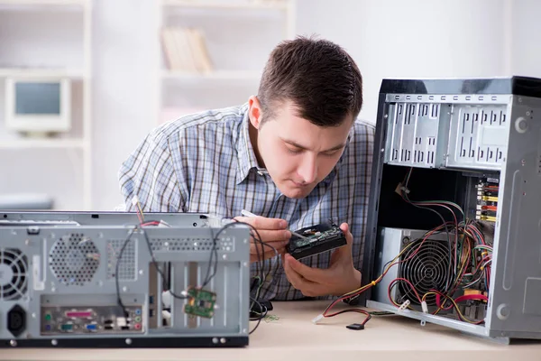 车间修理计算机的年轻技术员 — 图库照片