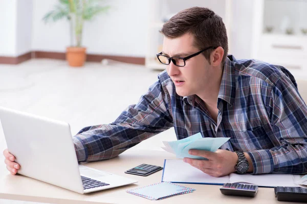 Junger Mann frustriert über sein Haus und Steuerrechnungen — Stockfoto