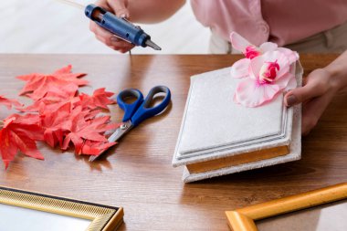 Hatıra defteri konseptinde resim çerçevesi dekore eden kadın