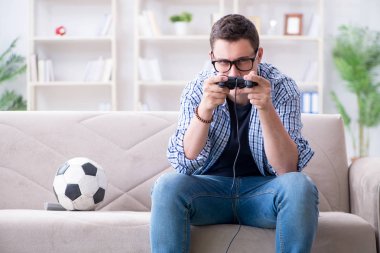 Genç adam evde bilgisayar oyunu oynuyor.