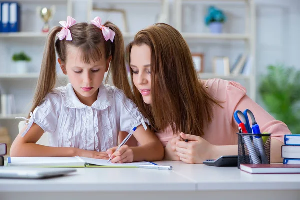 Mutter hilft ihrer Tochter bei Hausaufgaben — Stockfoto