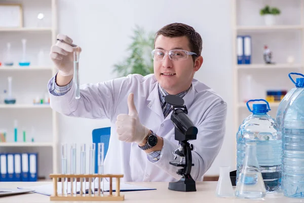 Joven estudiante de química experimentando en laboratorio — Foto de Stock