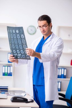 Klinikte çalışan genç erkek doktor.