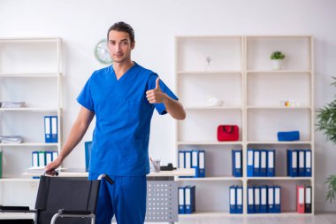 Klinikte çalışan genç erkek doktor.