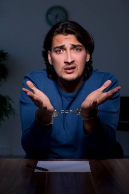 Genç mahkum karanlık odada oturuyor.