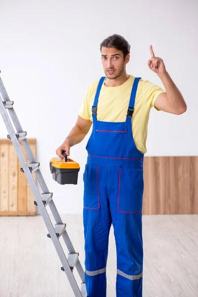 Jovem empreiteiro do sexo masculino trabalhando dentro de casa — Fotografia de Stock