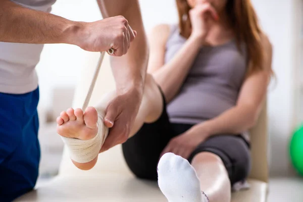 Leg injured woman visiting young doctor traumatologist — Stock Photo, Image