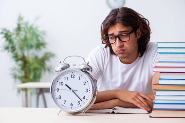 Sınıfta oturan genç erkek öğrenci.