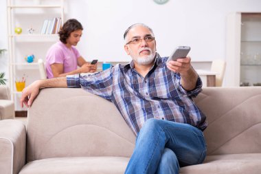 Genç öğrenci ve yaşlı büyükbabası evde.