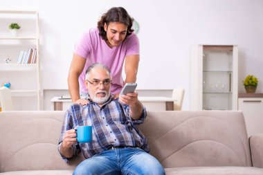 Genç öğrenci ve yaşlı büyükbabası evde.