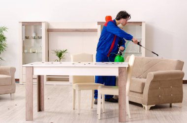 Genç müteahhit evde haşere kontrolü yapıyor.