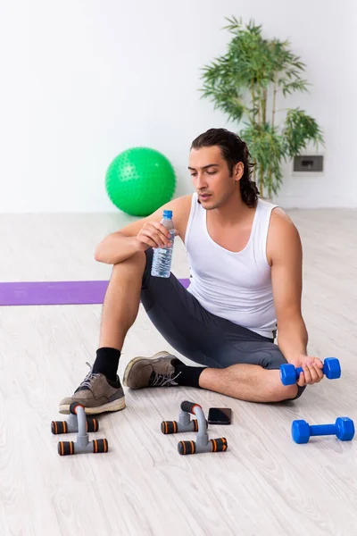 Junger gutaussehender Mann macht drinnen Sport — Stockfoto